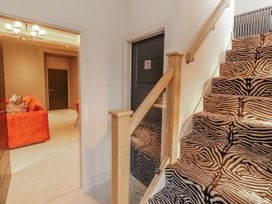 A hallway with a staircase and a view of a living room at Bounty Boutique on the Lakes Bowness-On-Windermere