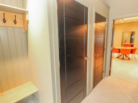 A hallway with doors and a bench at Bounty Boutique on the Lakes Bowness-On-Windermere