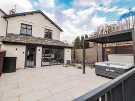 An outdoor area with a hot tub and seating at Bounty Boutique on the Lakes Bowness-On-Windermere