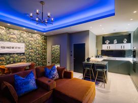 A living room with a couch and kitchen area at Bounty Boutique on the Lakes Bowness-On-Windermere