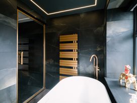 A bathroom with a bathtub and shower at Bounty Boutique on the Lakes, Bowness-On-Windermere