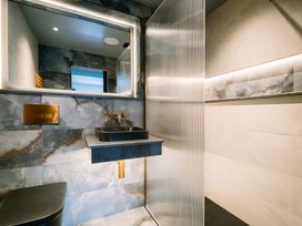 A bathroom with a sink, mirror, and shower at Bounty Boutique on the Lakes in Bowness-On-Windermere