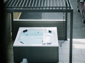 A hot tub under a pergola in an outdoor area at Bounty Boutique on the Lakes Bowness-On-Windermere
