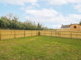 An outdoor garden with a grass area and wooden fence at Skye in Clee Hill