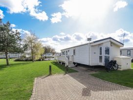 A mobile home with a deck and garden at 13 The Lakes in Mablethorpe