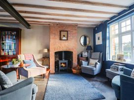 A living room with a fireplace and bookshelves at Bredy Cottages in Burton Bradstock