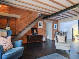 A living room with blue and grey chairs and a wooden table at Bredy Cottages in Burton Bradstock