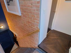 A staircase with brick wall and handrail at Bredy Cottages in Burton Bradstock