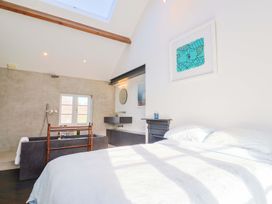 A bedroom with a bed and a bathtub at Bredy Cottages Burton Bradstock