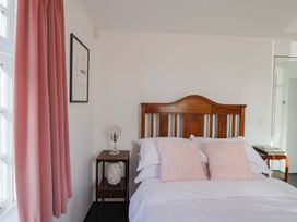 A bedroom with a bed and nightstand at Bredy Cottages in Burton Bradstock