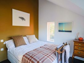 A bedroom with a bed and decor items at Bredy Cottages in Burton Bradstock