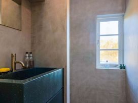 A bathroom with a sink and mirror at Bredy Cottages in Burton Bradstock