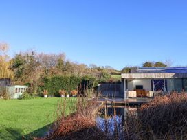 A garden with a house and shed at Bredy Cottages in Burton Bradstock