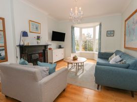 A living room with a sofa, coffee table and TV at Millmead House Portesham