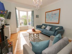 A living room with a sofa, coffee table and television at Millmead House in Portesham