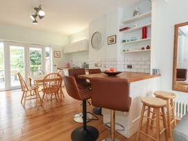 A kitchen with a dining table and bar stools at Millmead House in Portesham