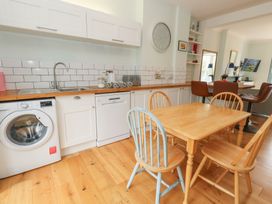 A kitchen with a washing machine and wooden table at Millmead House Portesham