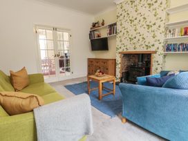 A living room with a green sofa and blue armchair at Millmead House in Portesham
