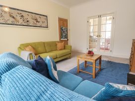 A living room with a green sofa and wooden coffee table at Millmead House in Portesham
