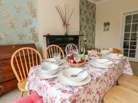 A dining room with a set table and fruit at Millmead House in Portesham