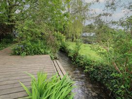 An outdoor area with a wooden deck and stream at Millmead House Portesham