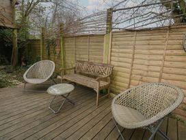A garden with seating furniture and wooden flooring at Millmead House Portesham