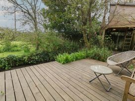 A garden area with decking, a chair, and table at Millmead House Portesham