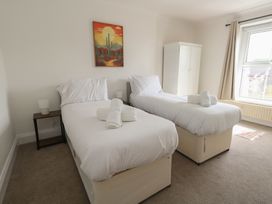 A bedroom with two beds and a wardrobe at Millmead House in Portesham