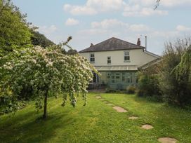 A house with a garden and flowering tree at Millmead House in Portesham