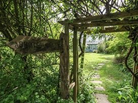 A garden with a signpost and a pathway at Millmead House Portesham