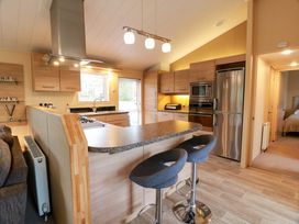 A kitchen with stove, sink, and refrigerator at L21 Coastal Kippford in Kippford near Sandyhills