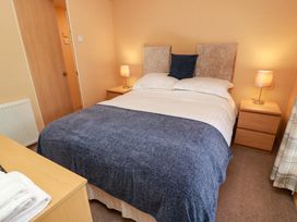 A bedroom with a bed and bedside table at L21 Coastal Kippford in Kippford near Sandyhills