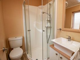 A bathroom with a shower, toilet, and sink at L21 Coastal Kippford near Kippford