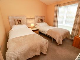 A bedroom with two single beds and a bedside table at L21 Coastal Kippford near Kippford