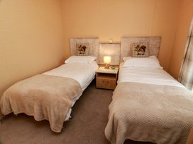 A bedroom with two single beds and a nightstand at L21 Coastal Kippford in Kippford near Sandyhills