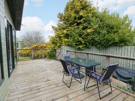 A wooden deck with a table and chairs at L21 Coastal Kippford in Kippford near Sandyhills