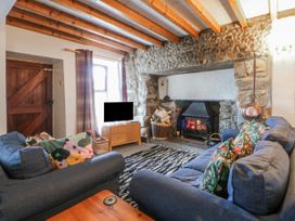 A living room with a sofa and fireplace at Llwyn Y Brig Isaf in Caernarfon