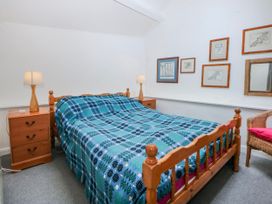 A bedroom with a bed and nightstands at Llwyn Y Brig Isaf in Caernarfon
