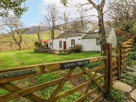 A cottage with a gate and lawn at Llwyn Y Brig Isaf in Caernarfon