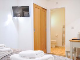 A bedroom with a television and an entryway to a bathroom at 3 Faraway Fields in Dobwalls