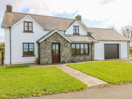 A house with stone wall and garage at Park Hall Cottage in Solva