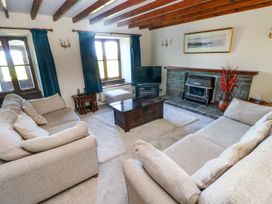 A living room with a television and fireplace at Park Hall Cottage in Solva