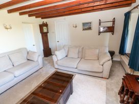 A living room with a sofa and a clock at Park Hall Cottage in Solva