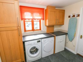 A laundry room with appliances and a window at Park Hall Cottage in Solva
