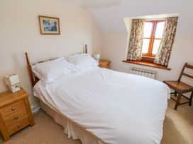 A bedroom with a bed and nightstands at Park Hall Cottage in Solva