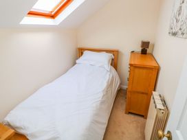 A bedroom with a single bed and a nightstand at Park Hall Cottage in Solva