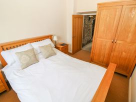 A bedroom with a bed and wooden wardrobe at Maerdy Lodge 