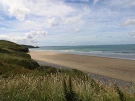 A beach view with grass in the foreground at Maerdy Lodge in 