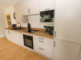 A kitchen with cabinets and appliances at Y Bwthyn Burry Port