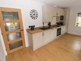 A kitchen with a sink and appliances at Y Bwthyn in Burry Port